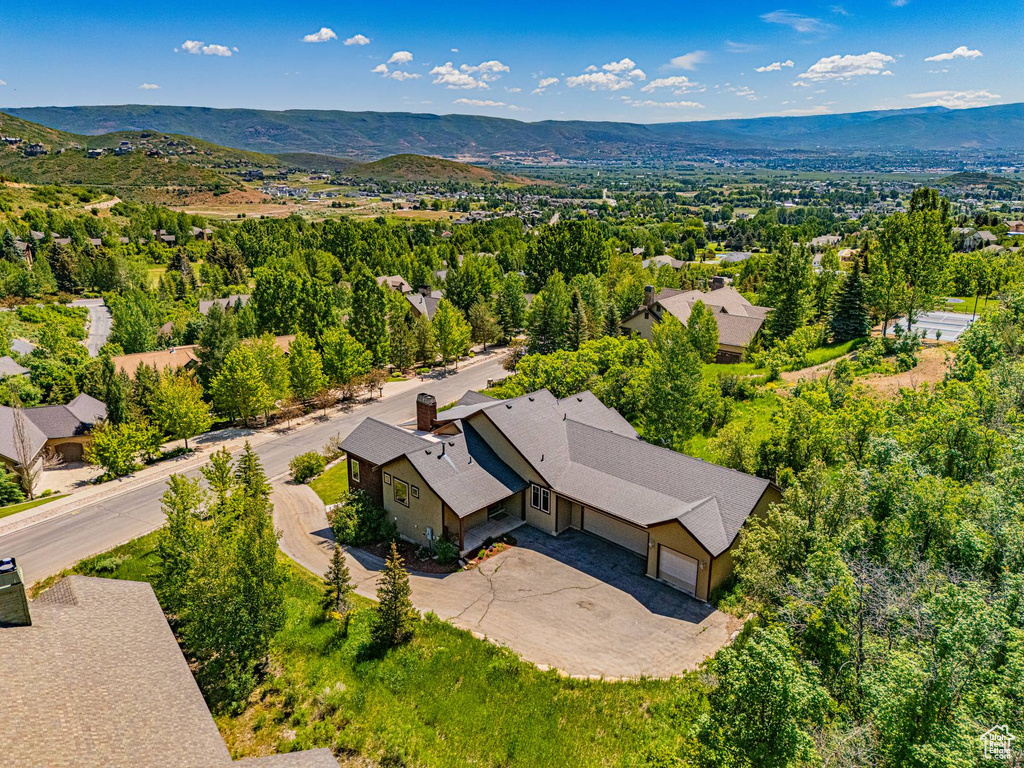 Aerial view of property and surrounding area featuring a mountain backdrop