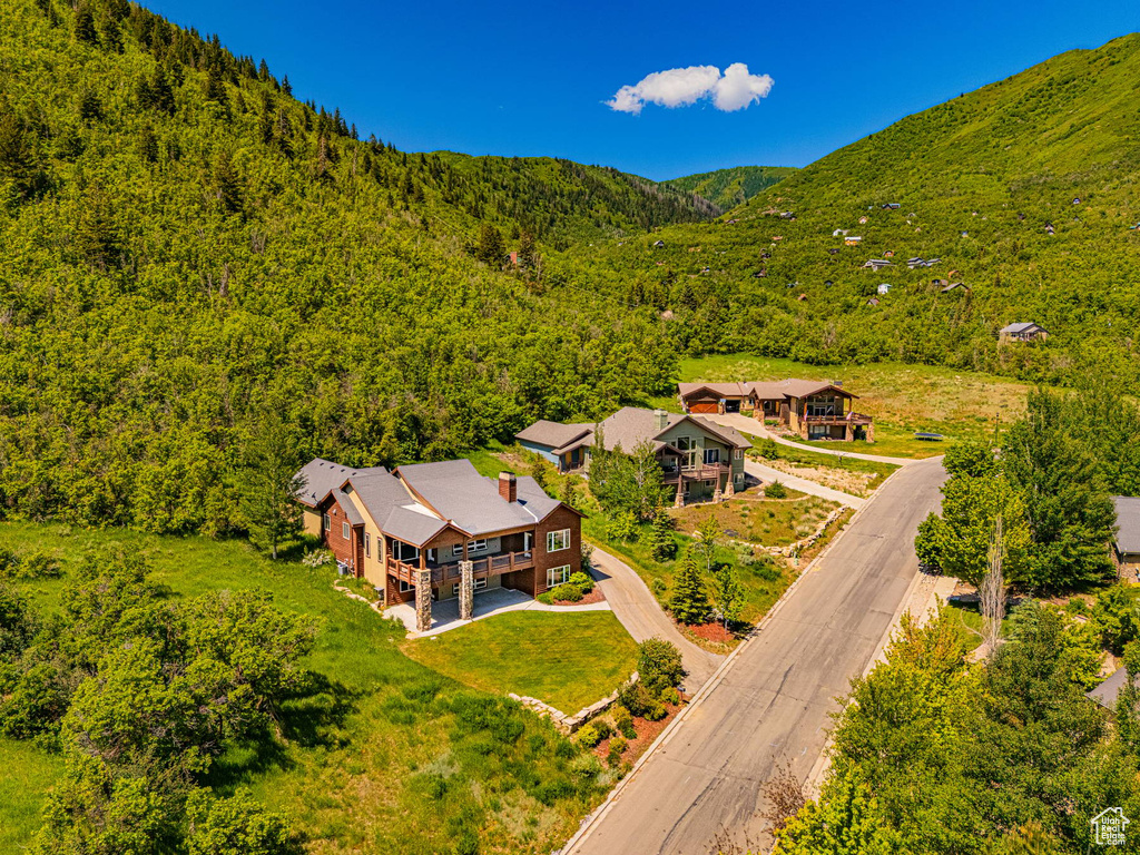 View of subject property featuring a heavily wooded area and a mountainous background