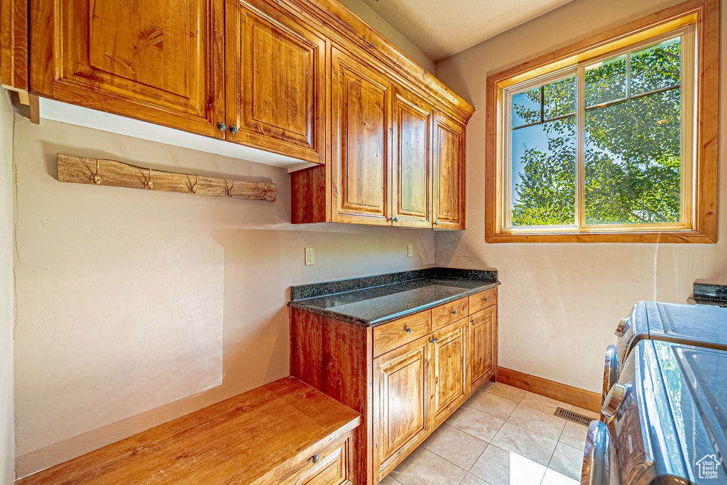 Laundry area with cabinet space, washer and dryer, plenty of natural light, and baseboards