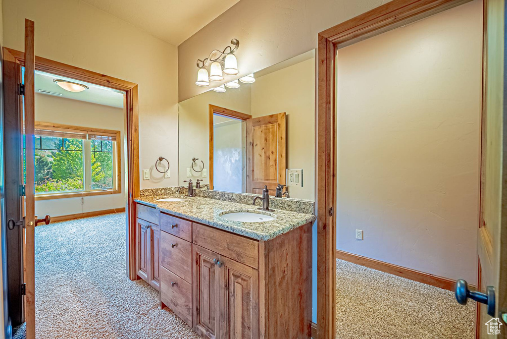 Full bath featuring baseboards and double vanity