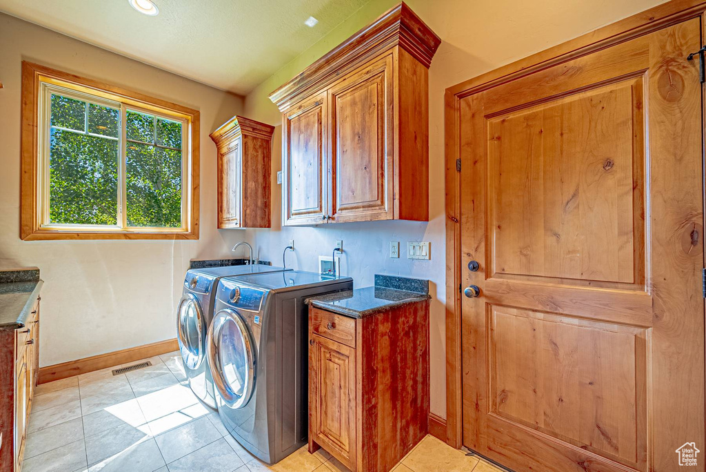 Washroom with cabinet space, baseboards, separate washer and dryer, light tile patterned flooring, and recessed lighting