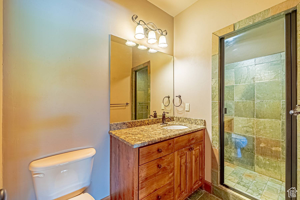 Full bath with toilet, vanity, and a stall shower