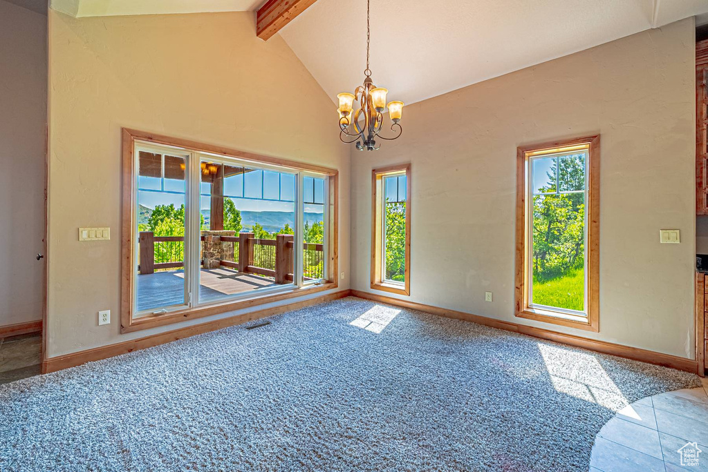 Carpeted spare room with beam ceiling, a chandelier, baseboards, and high vaulted ceiling