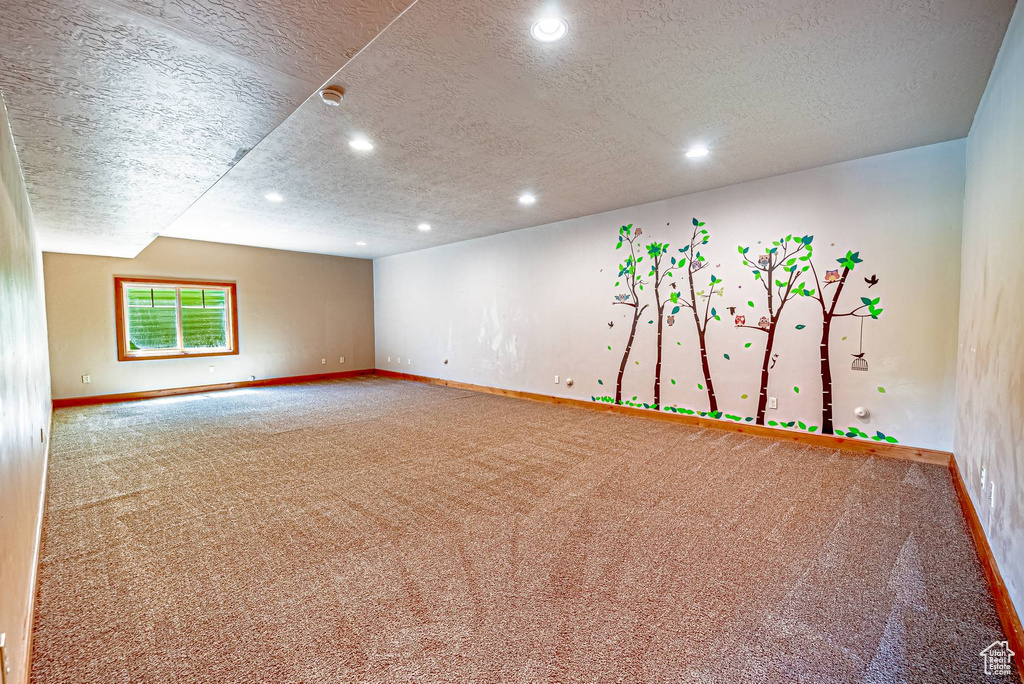 Carpeted spare room with baseboards, a textured ceiling, recessed lighting, and a smoke detector