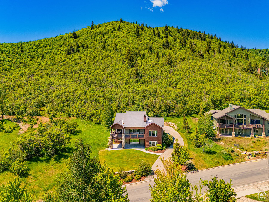 Aerial view of property and surrounding area with a heavily wooded area