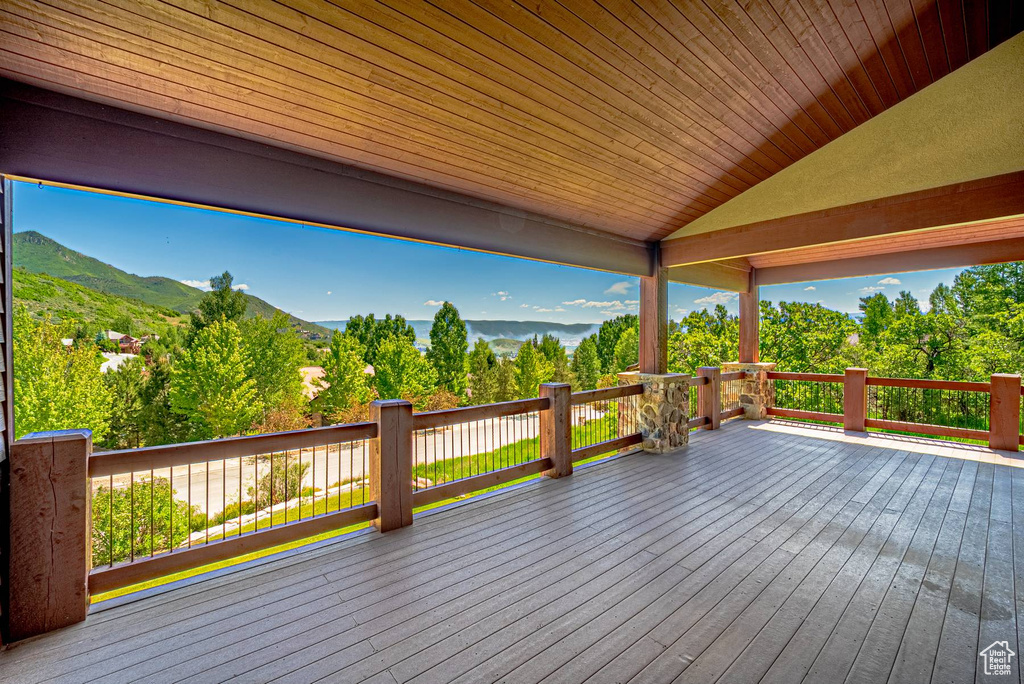 Deck with a mountain view and view of scattered trees