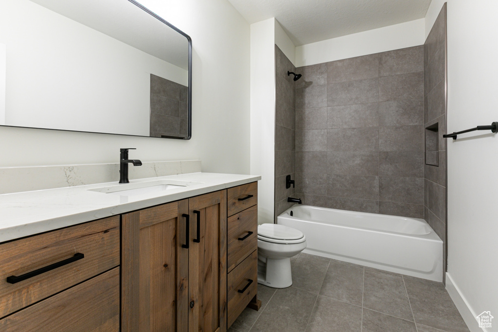 Full bathroom with shower / bathing tub combination, toilet, vanity, tile patterned floors, and baseboards