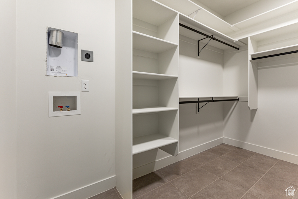 Spacious closet featuring dark tile patterned floors