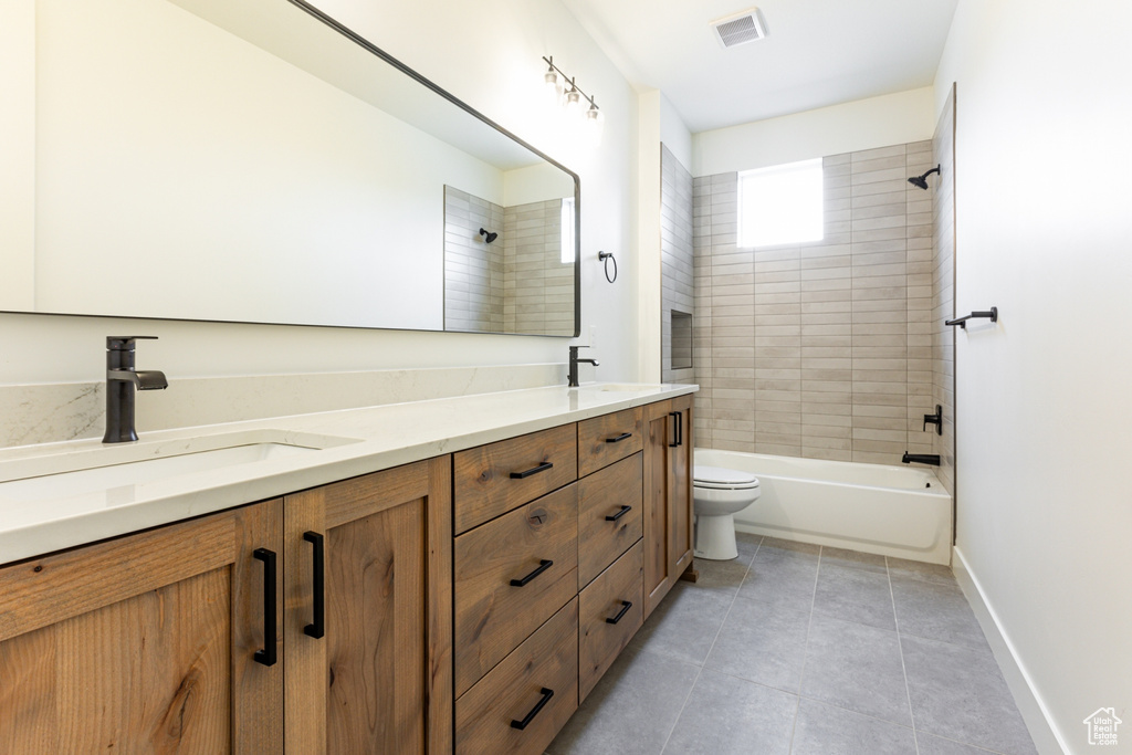 Bathroom with tile patterned flooring, visible vents, a sink, and double vanity