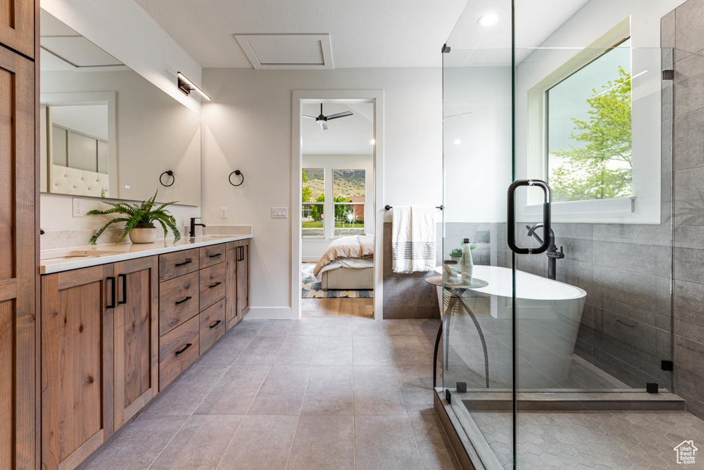 Ensuite bathroom with double vanity, ensuite bathroom, a soaking tub, and tile patterned floors