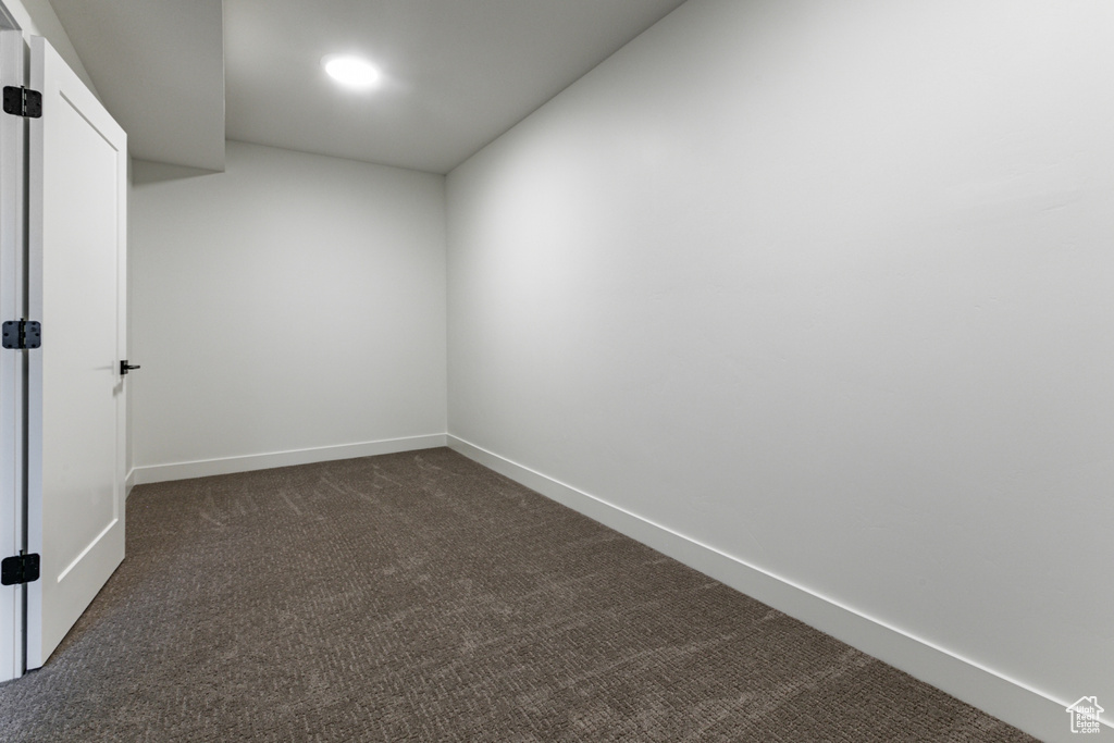 Unfurnished room featuring dark colored carpet, baseboards, and recessed lighting