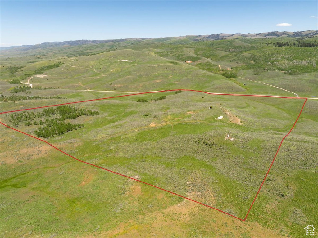 Aerial overview of property\'s location featuring property boundaries highlighted and a mountain backdrop