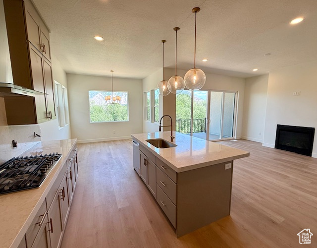 Kitchen with a sink, stainless steel appliances, light wood-type flooring, baseboards, and recessed lighting