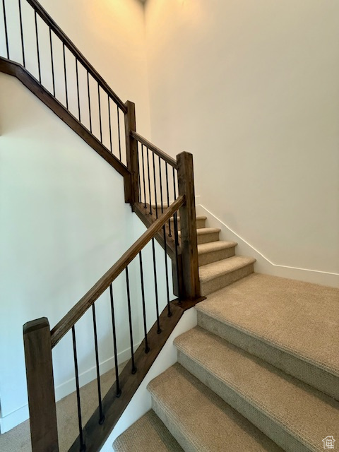 Staircase with carpet flooring and baseboards
