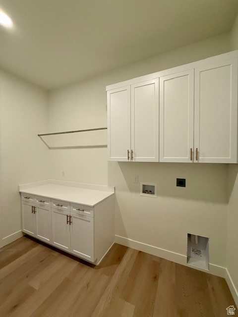 Laundry area with cabinet space, hookup for an electric dryer, light wood finished floors, hookup for a washing machine, and baseboards