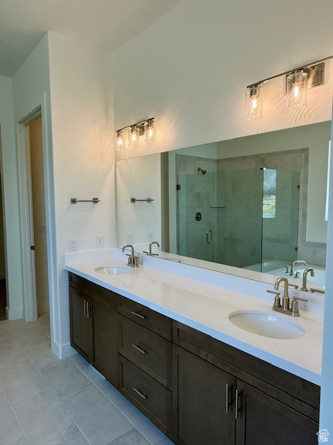Full bath featuring a stall shower, double vanity, and tile patterned flooring