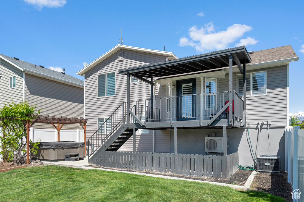Rear view of property with a hot tub, central AC, ac unit, and stairs