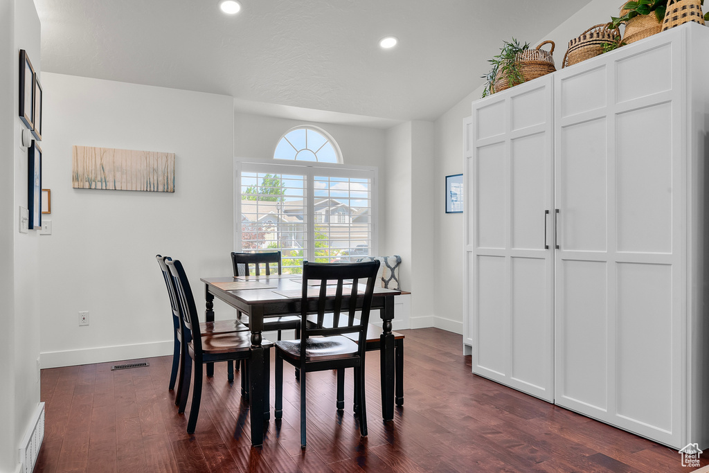 Dining space featuring dark wood-style floors, baseboards, recessed lighting, and lofted ceiling