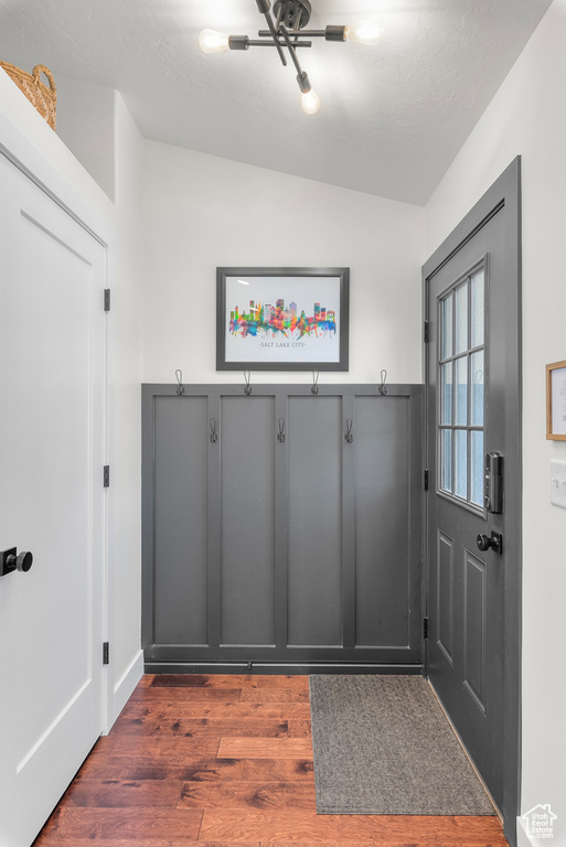 Mudroom featuring dark wood finished floors and vaulted ceiling