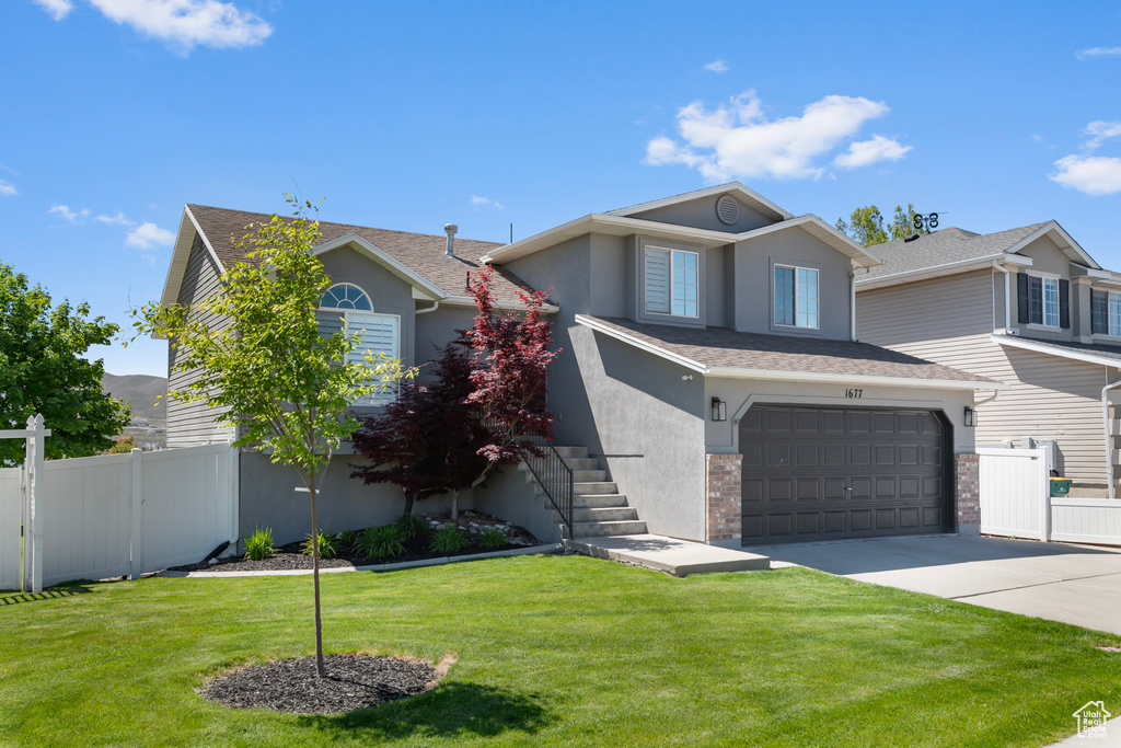 View of front of property featuring stucco siding, concrete driveway, stairway, an attached garage, and roof with shingles