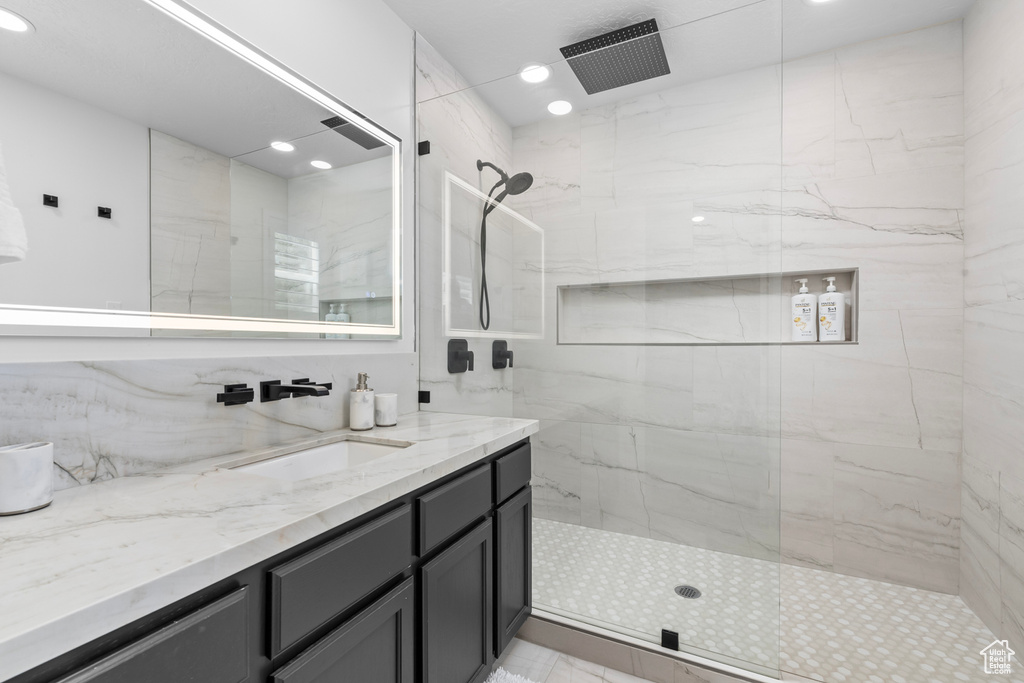 Full bath featuring vanity, walk in shower, and recessed lighting