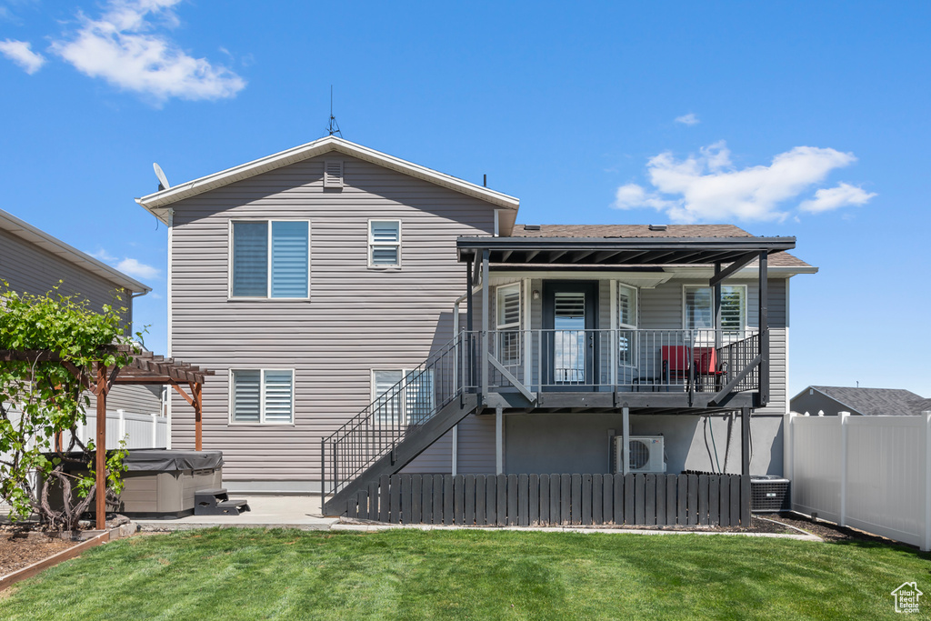 Back of property with a hot tub, stairway, a pergola, a patio area, and central AC unit