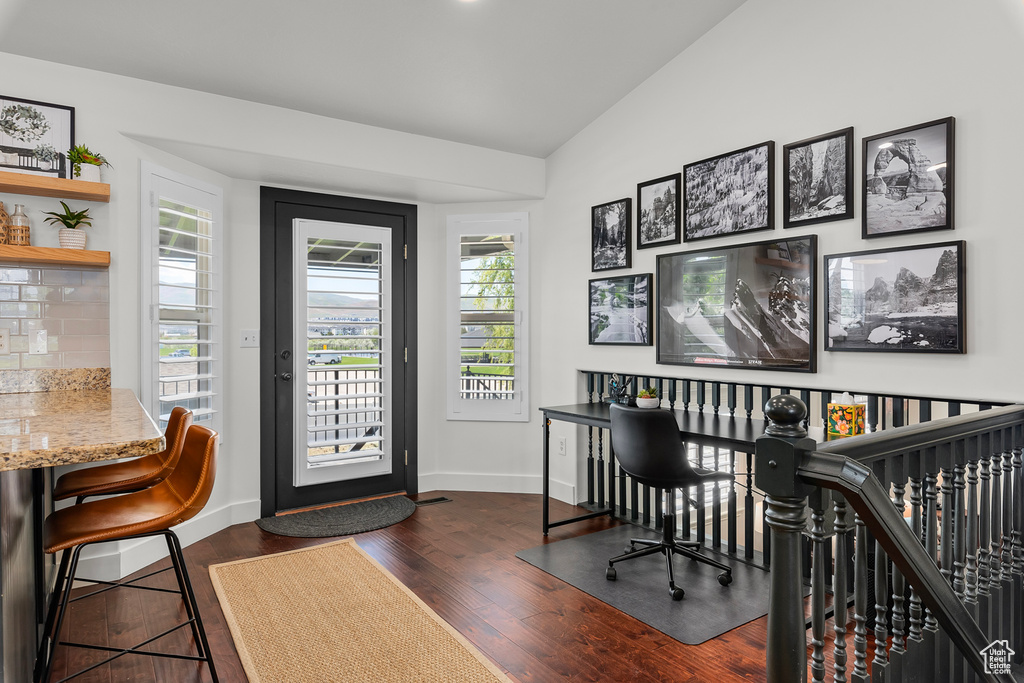 Office featuring vaulted ceiling, baseboards, and dark wood-style floors