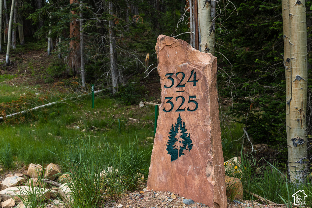 Custom carved stone marker featuring property numbers and a pine tree emblem