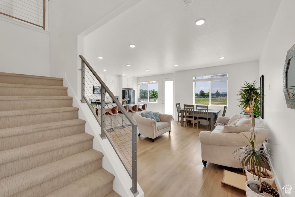 Stairs with wood finished floors and recessed lighting