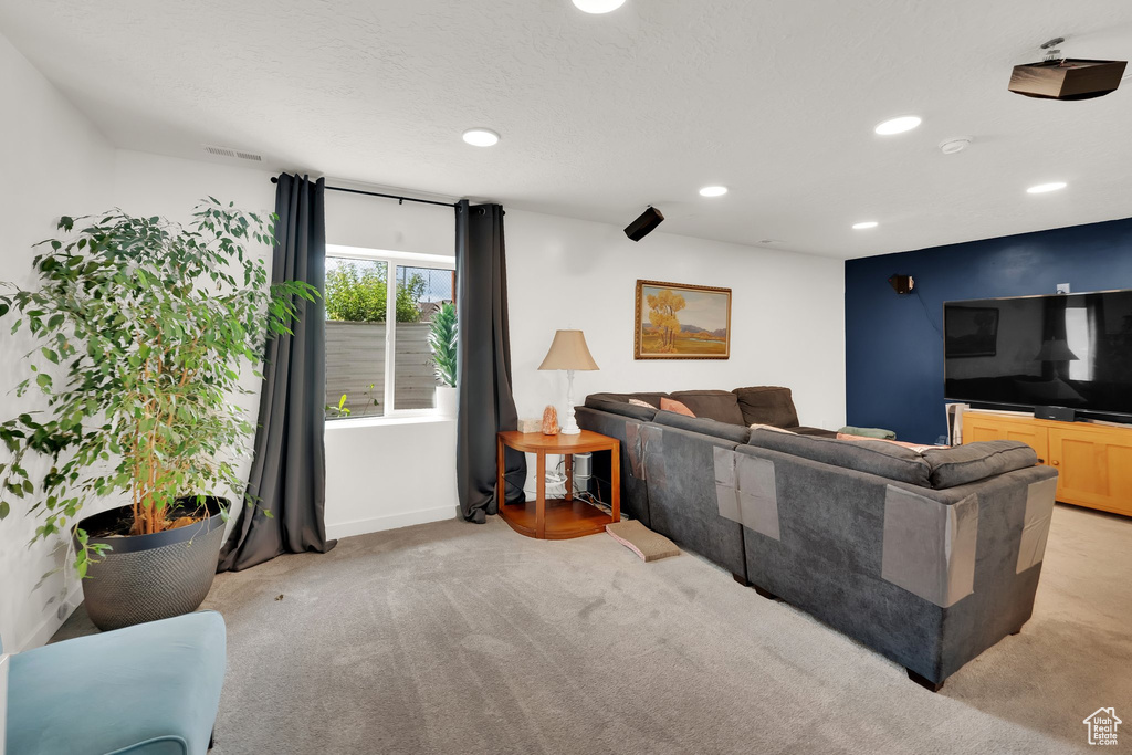 Living room with light colored carpet, recessed lighting, and baseboards