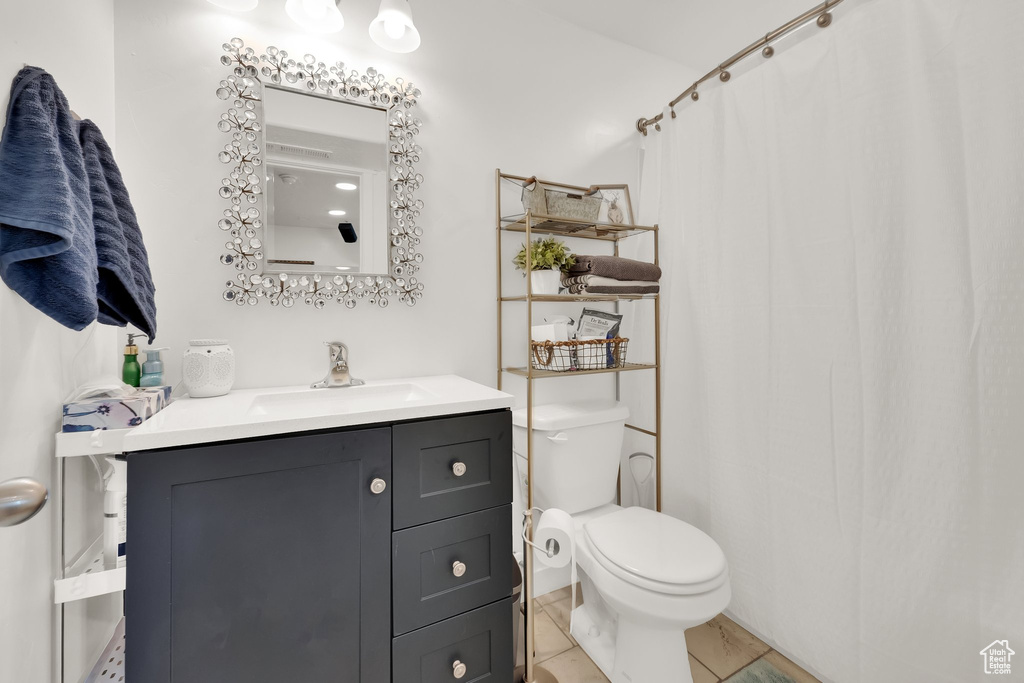 Bathroom with toilet, vanity, a shower with shower curtain, and tile patterned flooring