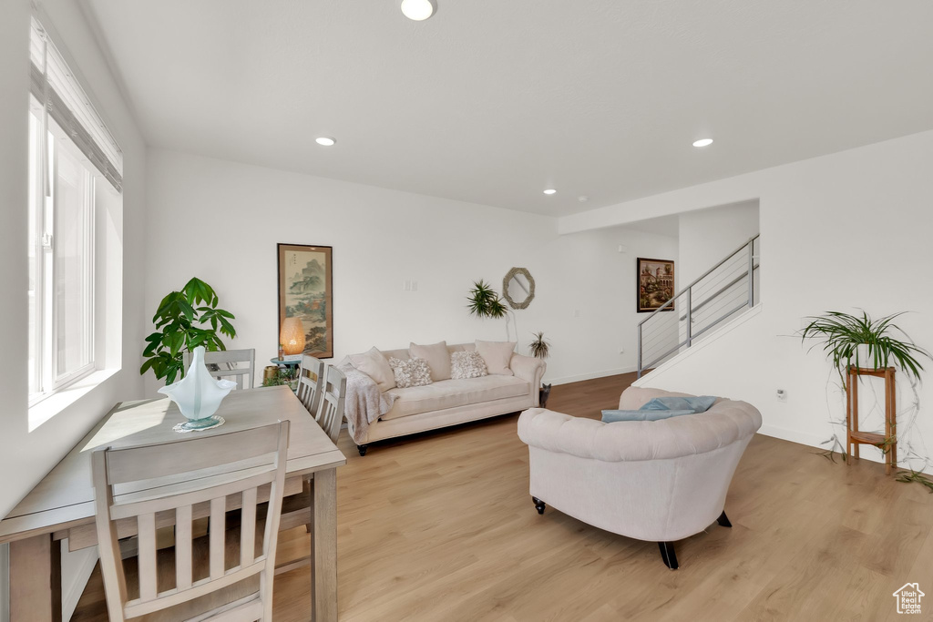 Living area with stairs, light wood-style floors, recessed lighting, and baseboards