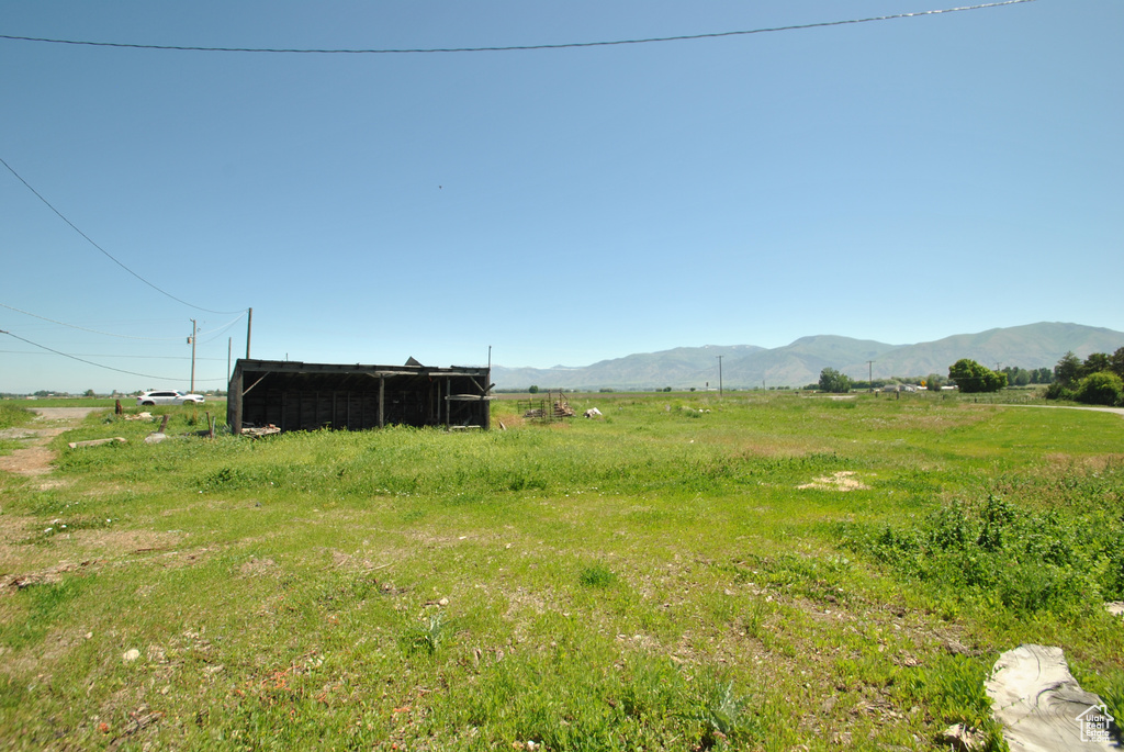 View of yard featuring a view of rural / pastoral area, a mountain view, an outdoor structure, and an outbuilding