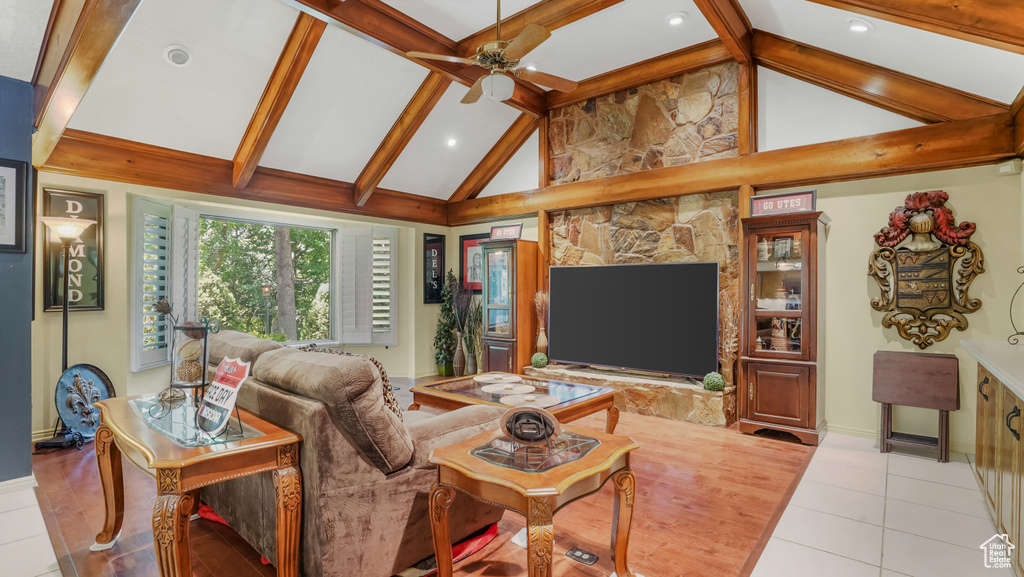 Living room featuring beamed ceiling, ceiling fan, light tile patterned flooring, baseboards, and recessed lighting