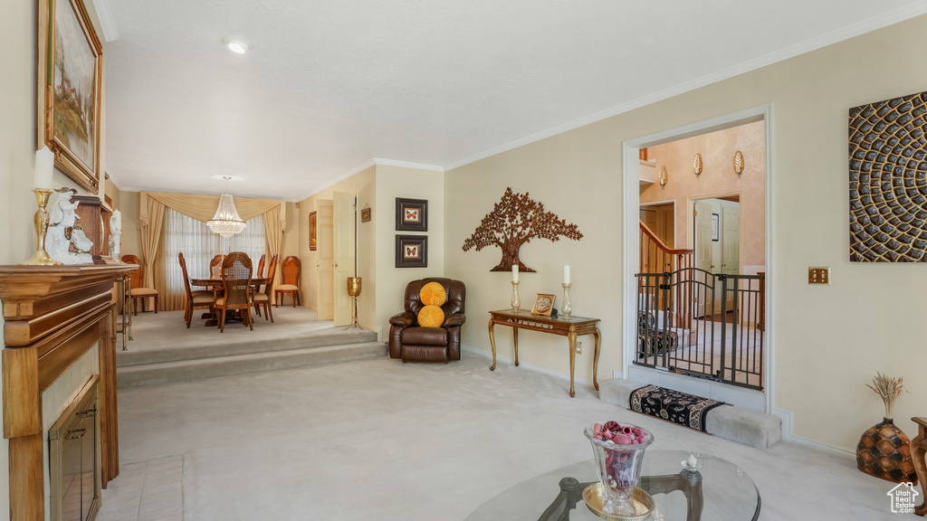 Living area featuring light carpet, stairway, baseboards, ornamental molding, and a chandelier