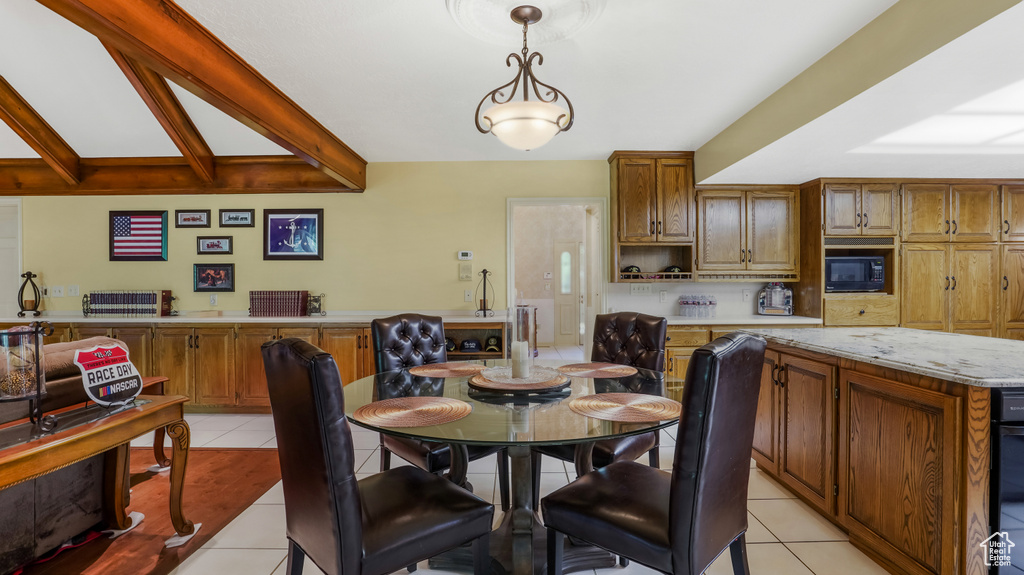 Dining space with light tile patterned floors and beam ceiling