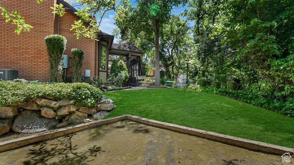 View of green lawn featuring central AC