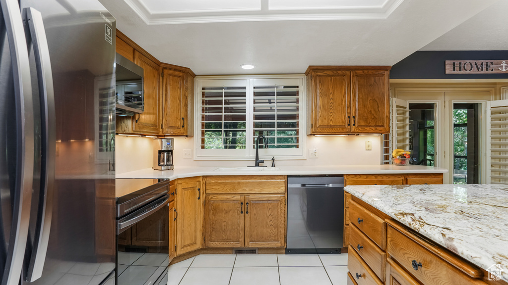 Kitchen featuring appliances with stainless steel finishes, a sink, light tile patterned floors, healthy amount of natural light, and recessed lighting
