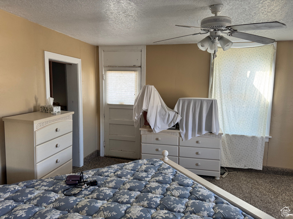 Bedroom featuring carpet flooring, a textured ceiling, and ceiling fan