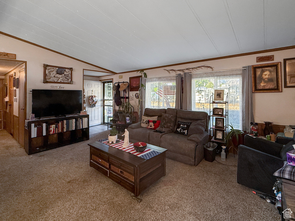 Carpeted living room featuring crown molding and lofted ceiling