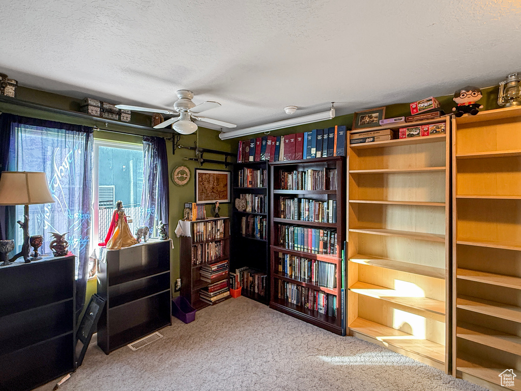 Sitting room with ceiling fan, a textured ceiling, and carpet