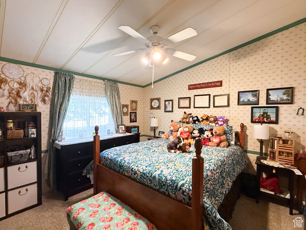 Bedroom featuring lofted ceiling, ornamental molding, wallpapered walls, carpet floors, and a ceiling fan