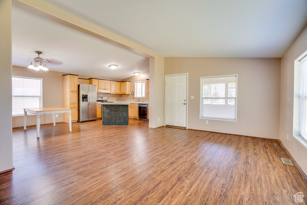 Unfurnished living room with light wood finished floors, ceiling fan, lofted ceiling, and baseboards