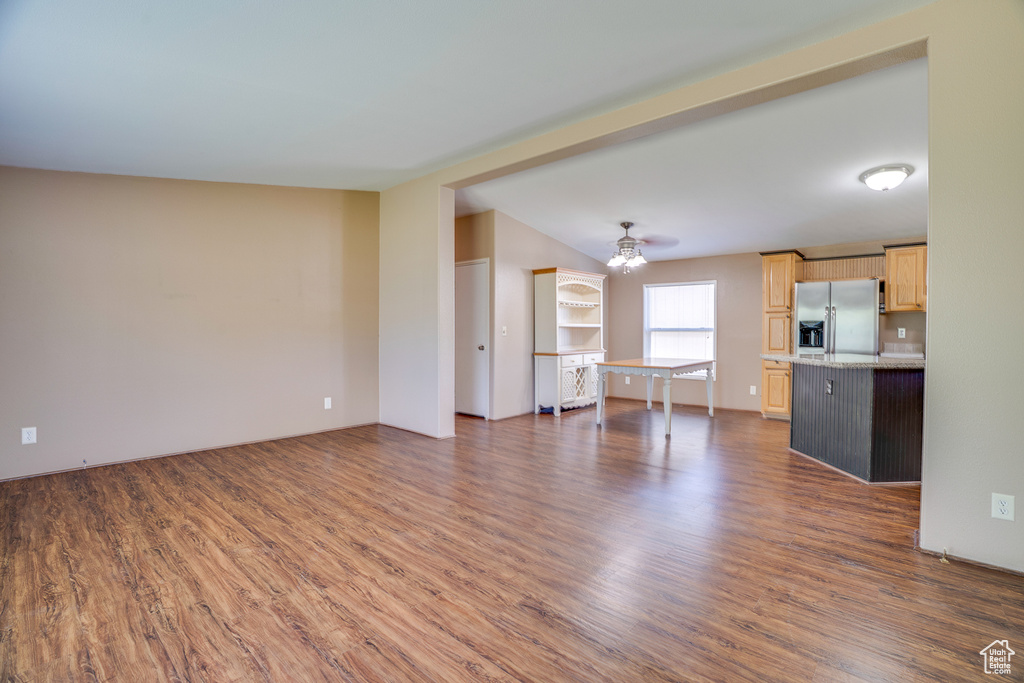 Unfurnished living room featuring dark wood-type flooring and ceiling fan