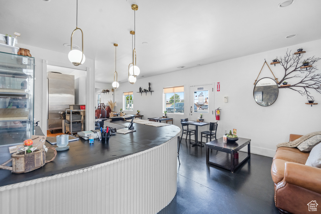 Kitchen with concrete floors, baseboards, and hanging light fixtures