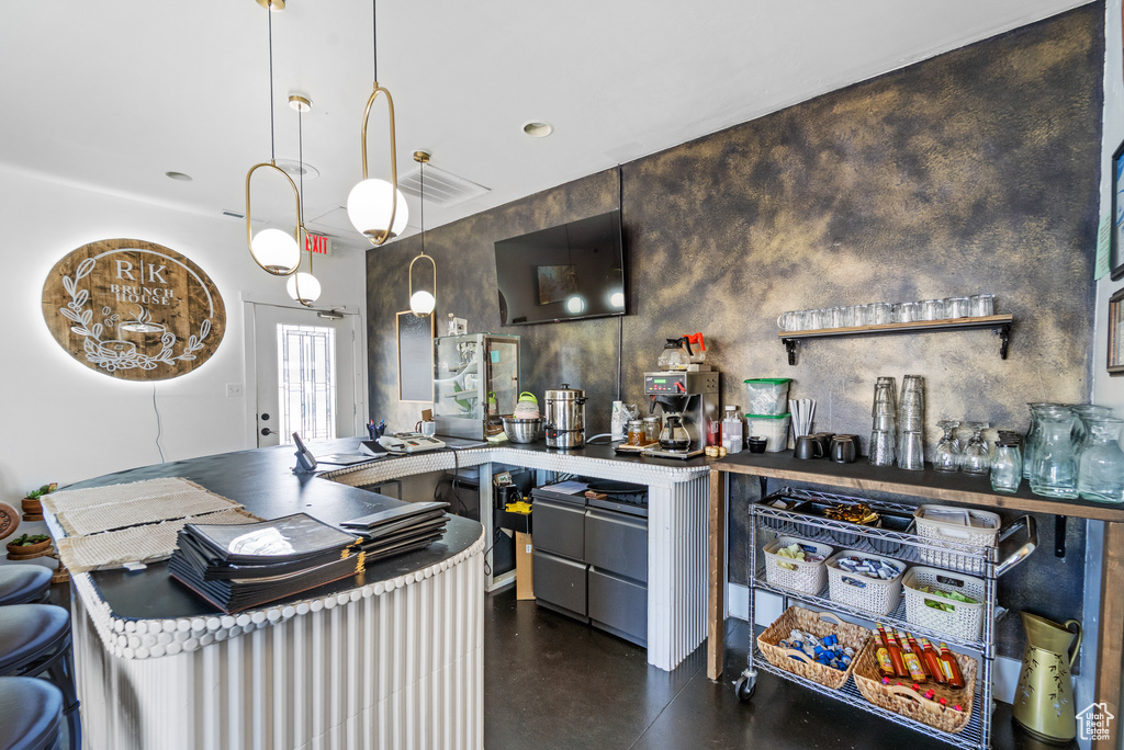 Bar area featuring finished concrete floors and decorative light fixtures