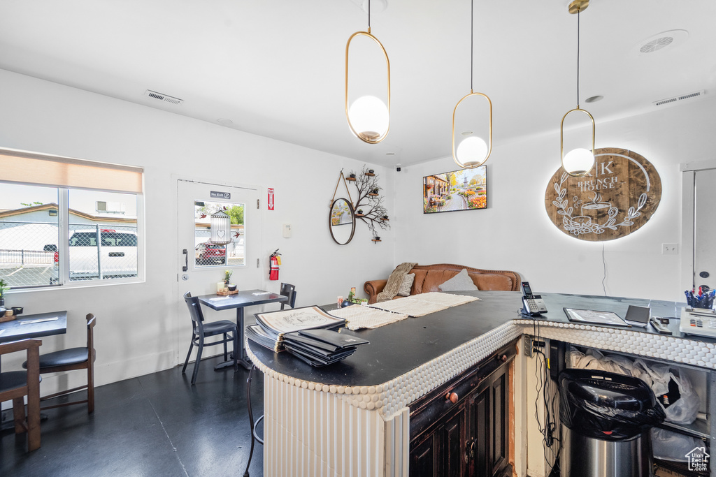 Kitchen featuring finished concrete floors, a kitchen bar, and baseboards