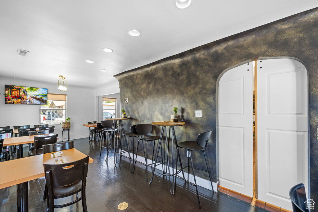 Dining area featuring arched walkways, recessed lighting, wood finished floors, and baseboards