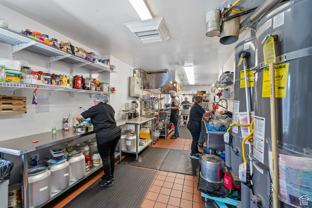 Miscellaneous room featuring tile patterned flooring, secured water heater, and a workshop area