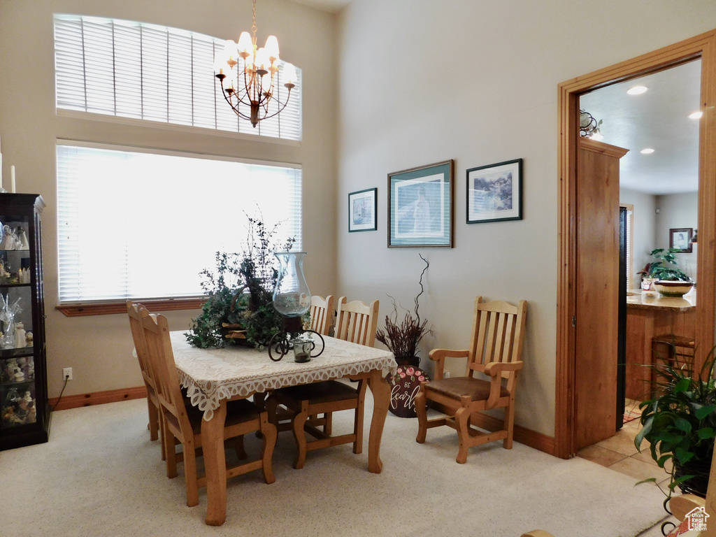 Carpeted dining room with baseboards, a chandelier, and recessed lighting
